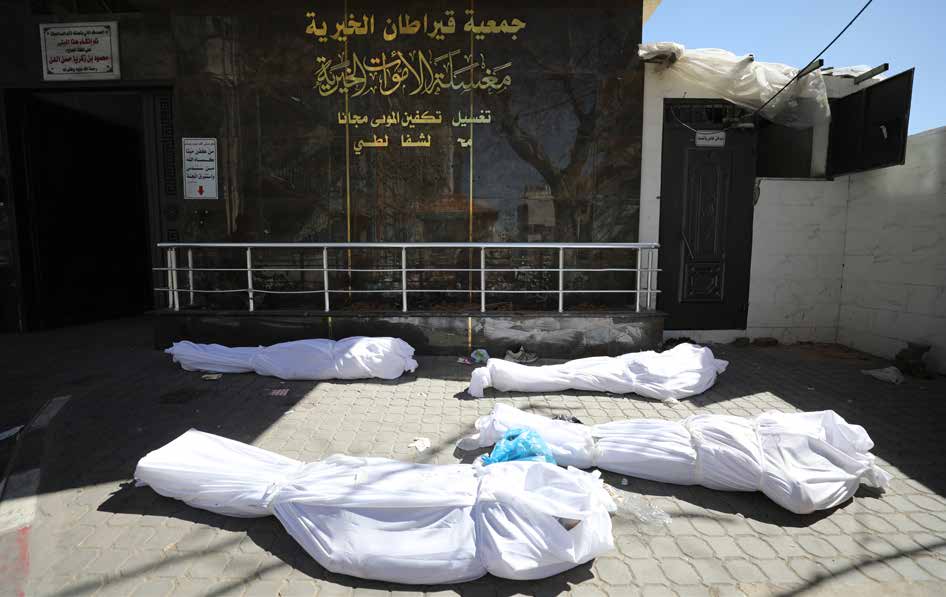 نقل جثامين الفلسطينيين الذين لقوا حتفهم في هجوم الجيش الإسرائيلي على مدنيين كانوا ينتظرون شاحنات المساعدات الإنسانية في شارع الرشيد جنوب غزة إلى مستشفى الشفاء.