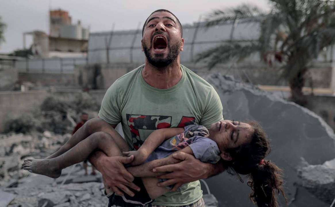 طفلة فلسطينية صغيرة فقدت حياتها تحت أنقاض مبنى دمرته الهجمات الإسرائيلية، وأحد أقاربها يصرخ بأسى وألم.