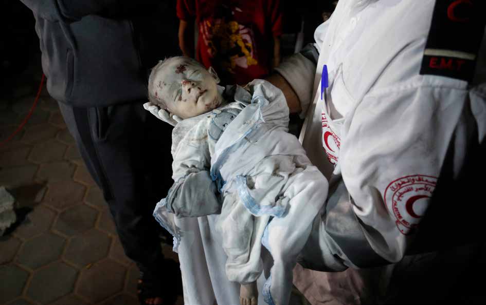 أحد موظفي الصحة يحمل جثة طفل رضيع. فقد العديد من الفلسطينيين، بمن فيهم الأطفال والرضع، حياتهم أو أصيبوا في الهجمات التي شنها الجيش الإسرائيلي على مخيم المغازي للاجئين. فيما جرى نقل القتلى والمصابين إلى مستشفى شهداء الأقصى في دير البلح.