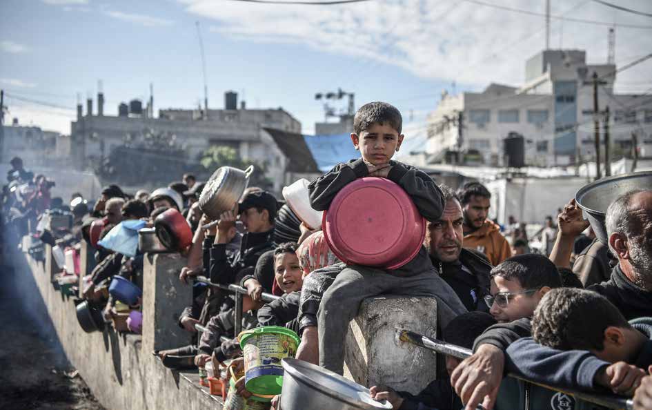 متطوّعون يطهون ويوزعون الطعام لعشرات الآلاف من سكان غزة، ممن أجبروا على النزوح إلى مدينة رفح تحت وطأة هجمات الجيش الإسرائيلي.