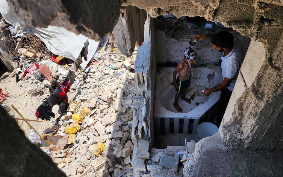 فلسطينيون يعيشون على أنقاض منازلهم المدمرة نتيجة الهجمات المتواصلة للجيش الإسرائيلي على غزة منذ عدة أشهر. في منطقة بني سهيلة بمدينة خان يونس، تقوم إحدى العائلات الغزاوية بغسل أطفالها في الحمام الذي بقي من منزلهم المدمر.
