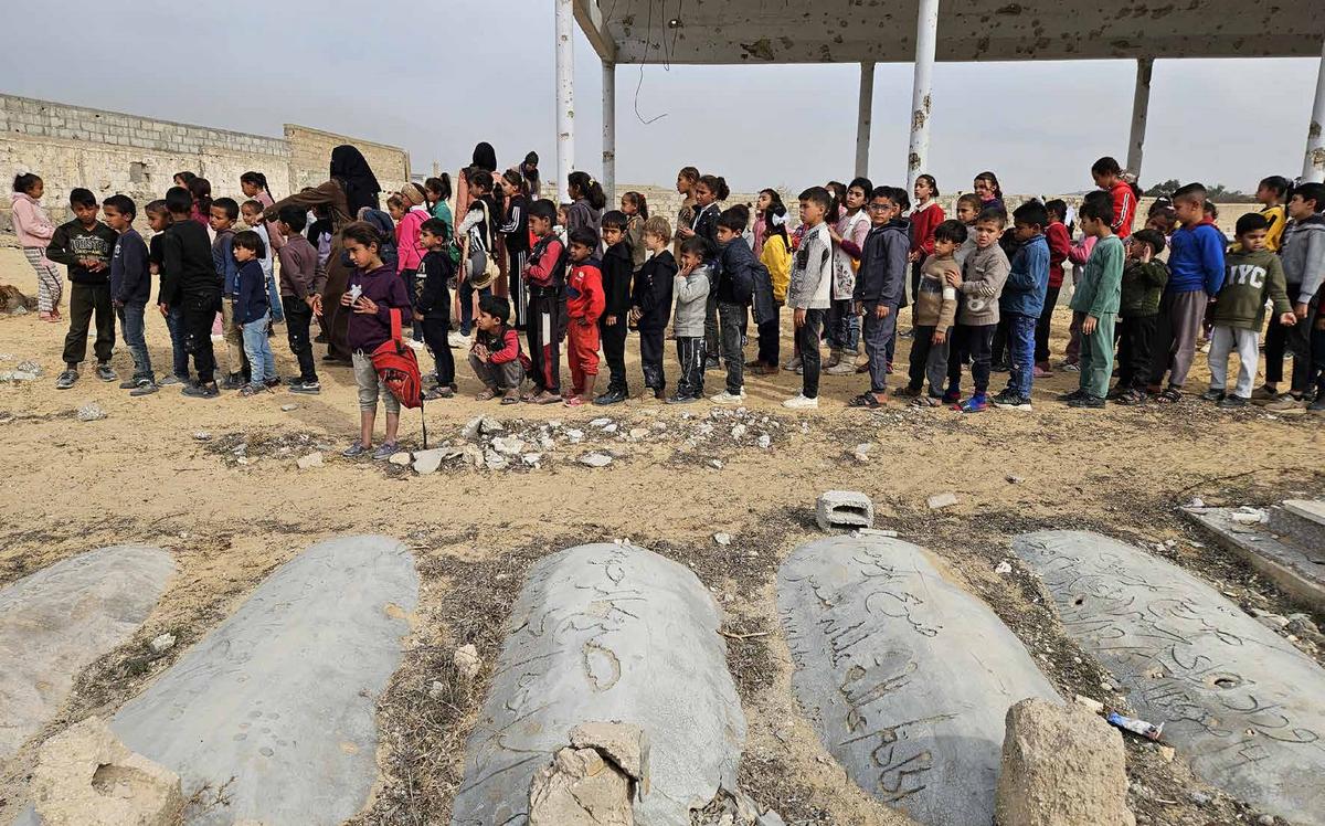 مع دخول الهجمات الإسرائيلية على غزة عامها الثاني، حُرم آلاف الطلاب من حقهم في التعليم. ففي مدينة خان يونس جنوب قطاع غزة، اضطر الطلاب إلى استكمال دراستهم داخل مقبرة، بسبب تدمير عدد من المدارس جراء القصف، وتحويل أخرى إلى مراكز إيواء للنازحين. ورغم الإمكانات المحدودة، يحاول الأطفال مواصلة تعليمهم وسط الركام والمعاناة.