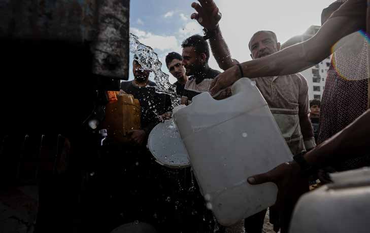 يصطفّ الفلسطينيون وهم يحملون عبوات بلاستيكية للحصول على المياه من شاحنة توزيع، في ظل أزمة مياه خانقة ناجمة عن الهجمات الإسرائيلية في مدينة غزة. ومنذ أكثر من 20 شهرًا، خسر العديد من الفلسطينيين منازلهم جراء القصف، ويقيمون اليوم في خيام بسيطة بجانب المباني المدمرة أو المتضررة. وتواجه العائلات النازحة صعوبات كبيرة في الحصول على المأوى، والغذاء، والمياه النظيفة، ومواد النظافة، والرعاية الصحية. أما الأطفال، فيحاولون التمسّك بالحياة من خلال ألعاب بسيطة يمارسونها بين الخيام والركام، في ظل أجواء الحرب.