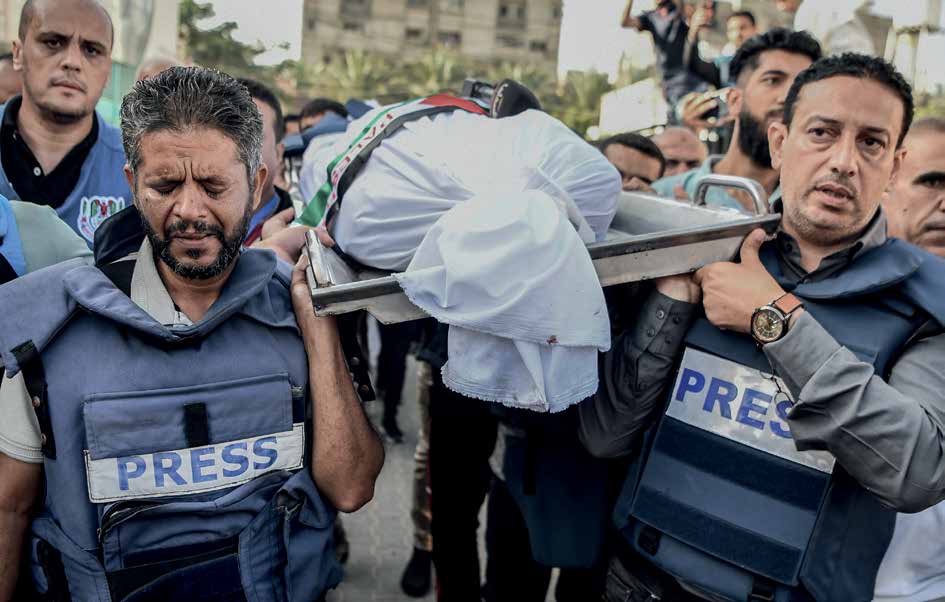 في 3 نوفمبر/ تشرين الثاني 2023، مراسم جنازة مراسل تلفزيون فلسطين محمد أبو حطب، الذي فقد حياته مع 10 من أفراد أسرته جراء غارة جوية استهدفت منزله في مدينة خان يونس بقطاع غزة. زملاؤه يحملون جثمانه خلال التشييع وسط أجواء مليئة بالحزن والأسى.