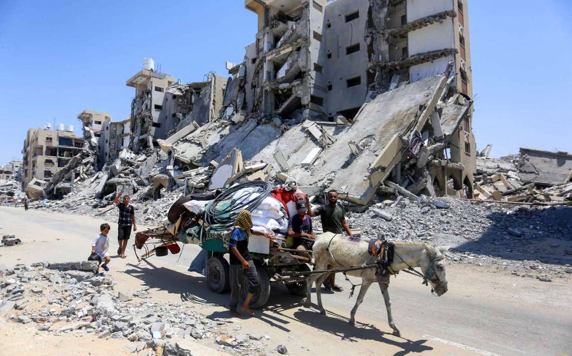 عائلة فلسطينية تجبر على مغادرة منطقة حمد في خان يونس بعد تحذيرات الجيش الإسرائيلي لإخلاء المنطقة.