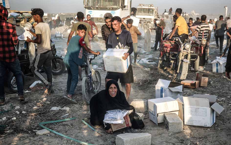 Palestinians gather along the Netzarim Corridor in hopes of receiving food and essential supply boxes sent by aid organizations.