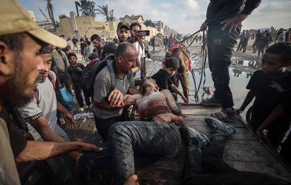 Israeli forces attacked Palestinians gathered to receive aid in the Zakim area of northern Gaza. The dead and wounded are evacuated from the scene amid the chaos.